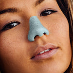 Load image into Gallery viewer, A girl wearing Nöz’s vegan nose sunscreen in the color blue.
